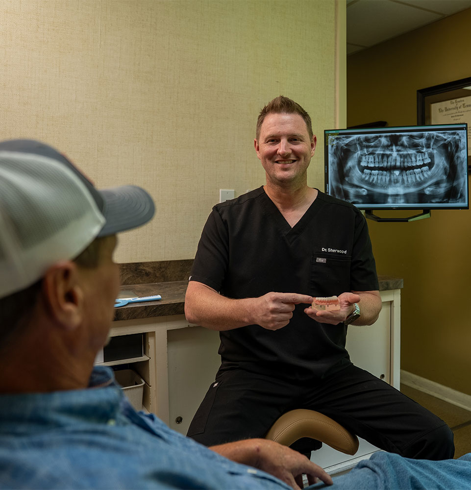 Doctor pointing at a model of dental implants