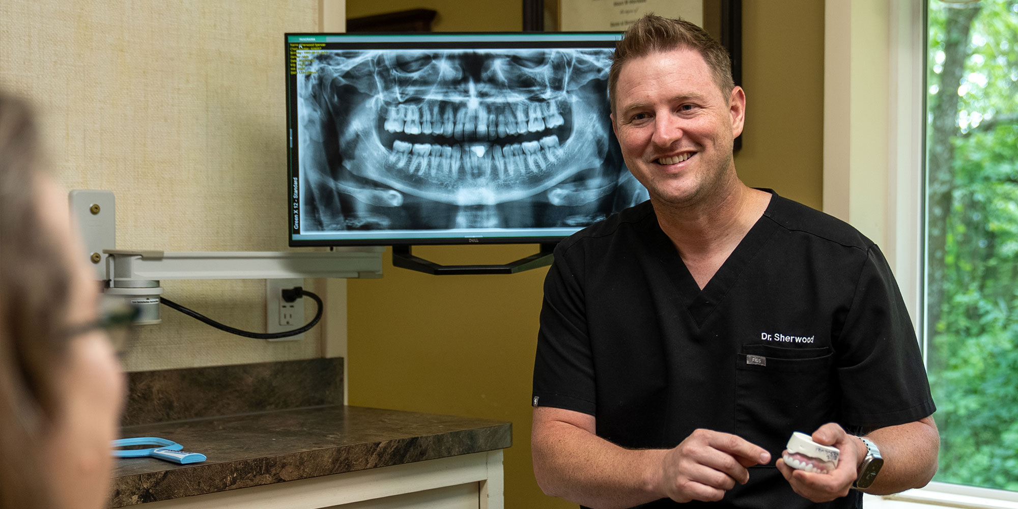 Doctor Holding a model full arch implants