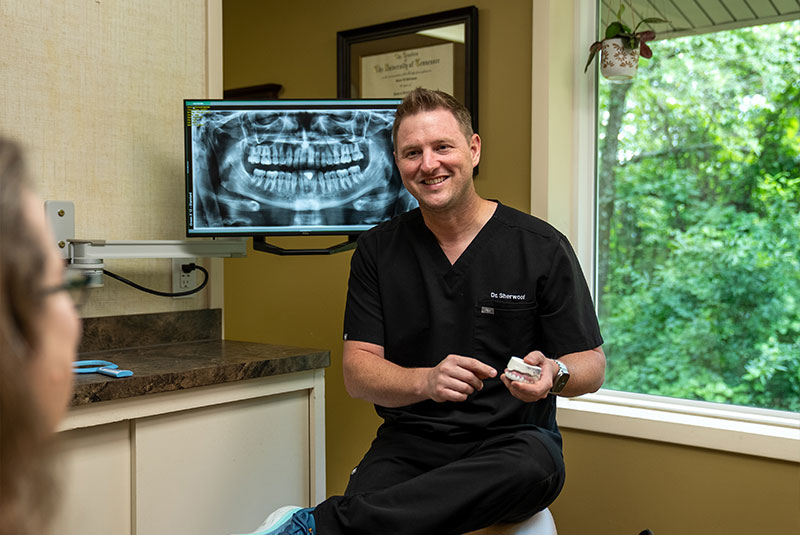 Doctor pointing at a model of dental implants
